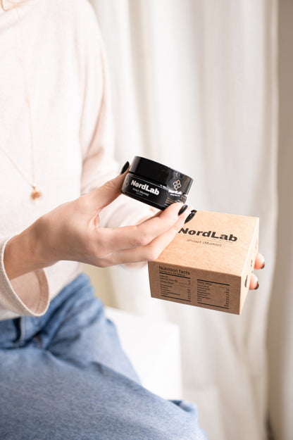 Person holding a NordLab product with a box in front of a white curtain